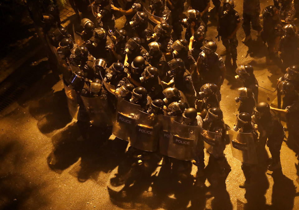 CORRECTS DATE TO EARLY FRIDAY, JUNE 12 Riot police advance to push back the anti-government protesters from a square near the government house, during a protest against the political leadership they blame for the economic and financial crisis, in downtown Beirut, Lebanon, early Friday, June 12, 2020. (AP Photo/Hussein Malla)