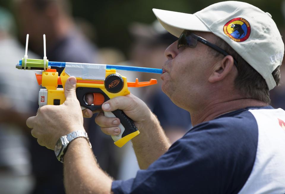 A competitor takes aim with a customised pea shooter during the 2014 World Pea Shooting Championship in Witcham, southern England