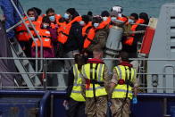 A group of people thought to be migrants are brought in to Dover, Kent, England, by the RNLI, following a small boat incident in the Channel, Thursday April 14, 2022. Britain's Conservative government has struck a deal with Rwanda to send some asylum-seekers thousands of miles away to the East African country. Opposition politicians and refugee groups are condemning the plan as unworkable, inhumane and a waste of public money. (Gareth Fuller/PA via AP)