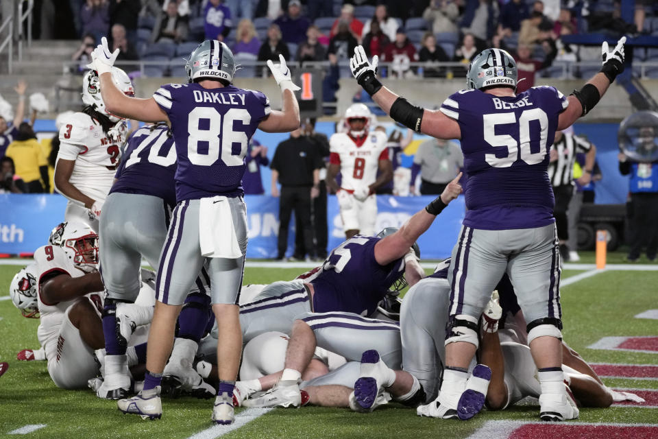 Kansas State tight end Garrett Oakley (86) and offensive lineman Cooper Beebe (50) signal "touchdown" as teammate running back DJ Giddens scores against North Carolina State during the first half of the Pop-Tarts Bowl NCAA college football game, Thursday, Dec. 28, 2023, in Orlando, Fla. (AP Photo/John Raoux)