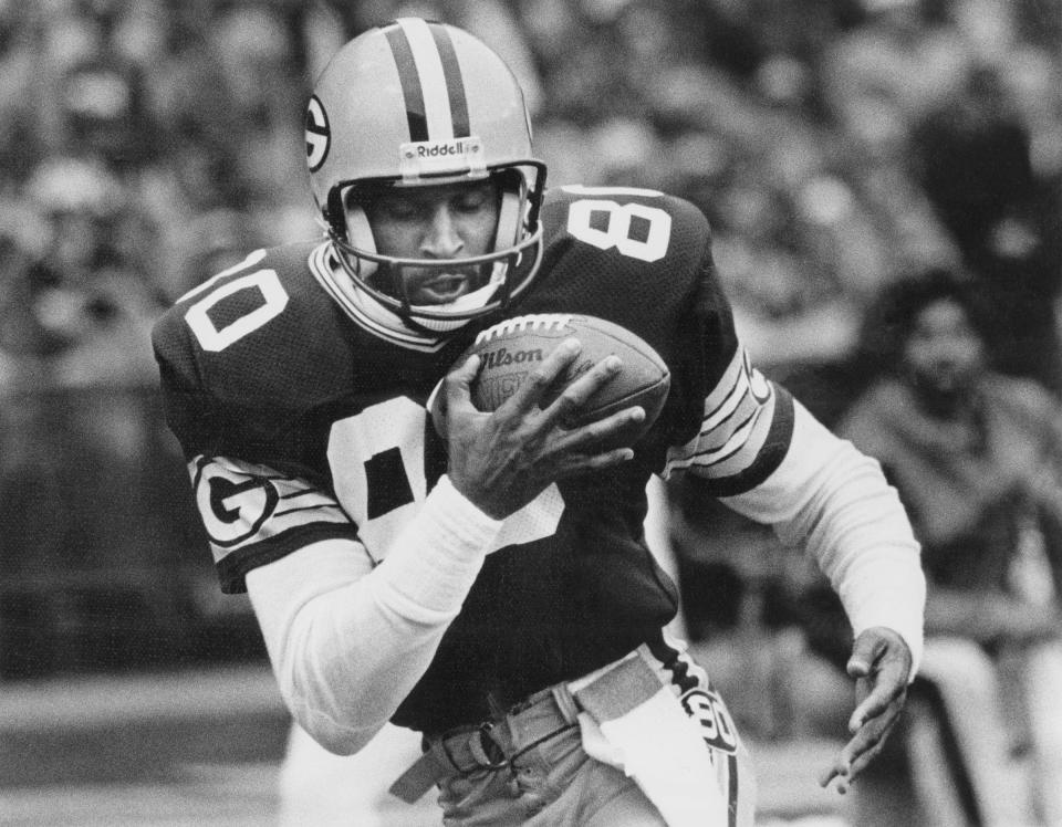 James Lofton runs with the football during a game in 1984.