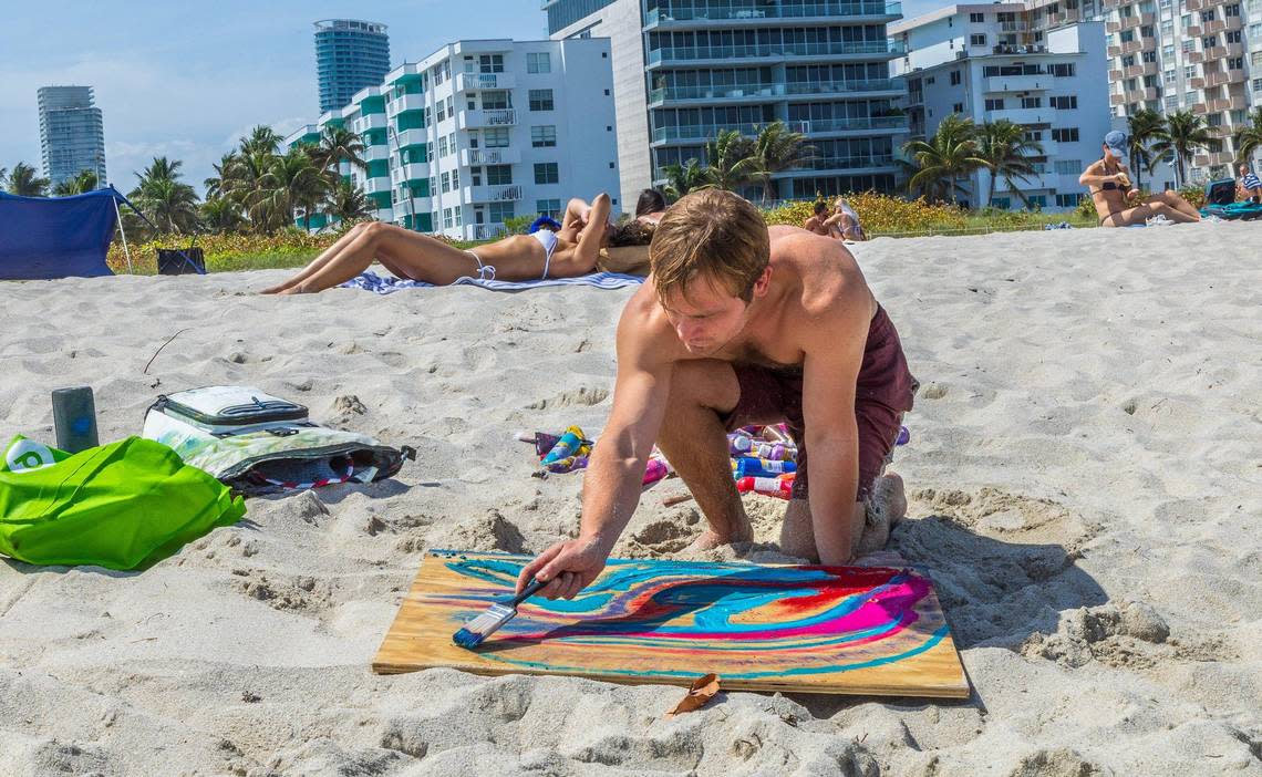 Artist Cole Myers, a South Beach resident works on a piece in the sand, during spring break in Miami Beach, on Saturday March 16, 2024.