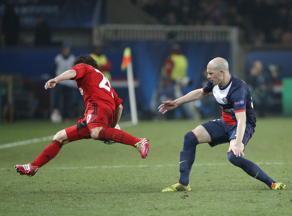 PSG's Christophe Jallet, right, and Leverkusen's Andres Guardado challenge for the ball during the Champions League round of 16 second leg soccer match between Paris Saint Germain and Bayer Leverkusen at the Parc des Princes stadium in Paris, Wednesday, March 12, 2014. (AP Photo/Christophe Ena)