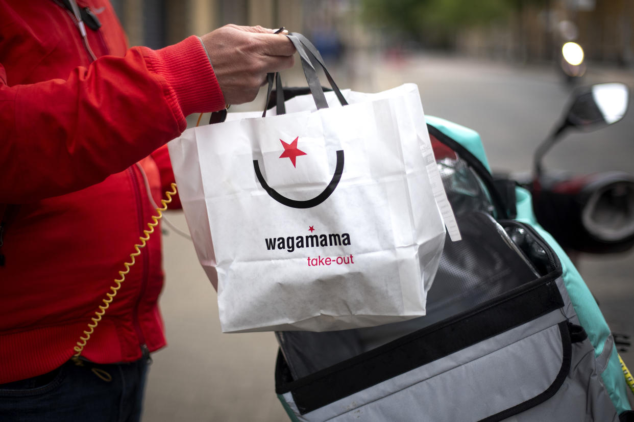 A Deliveroo driver collects a Wagamama takeaway bag from Wagamama Hackney delivery kitchen in East London, as the UK continues in lockdown to help curb the spread of the coronavirus.