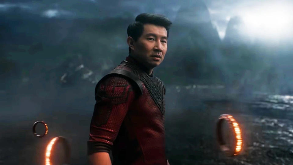 Shang-Chi standing in front of a misty background with three of the ten rings