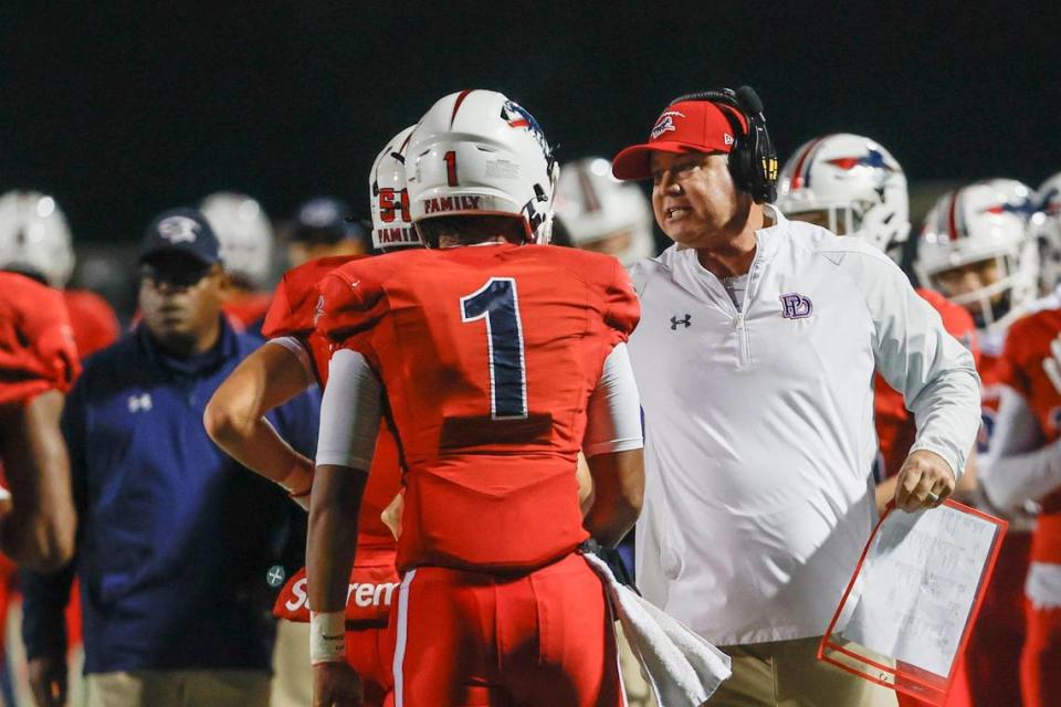 Providence Day head coach Chad Grier talks to quarterback Jadyn Davis after Davis ran for a touchdown against Rabun Gap in the first half in Charlotte, N.C., Friday, Oct. 20, 2023. (Nell Redmond photo)