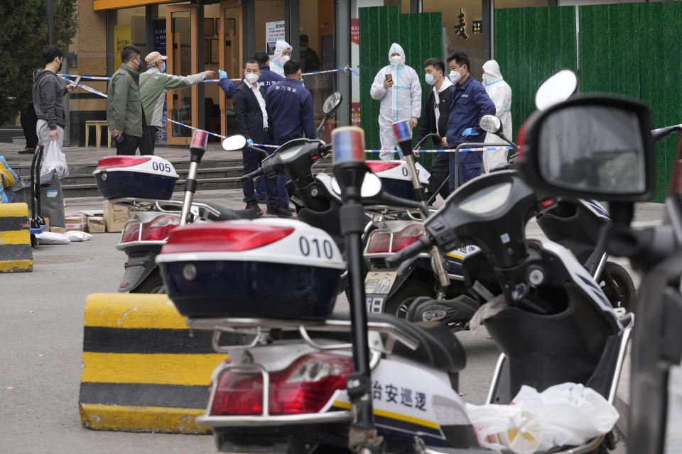 Workers control access into a lockdown community on Sunday, March 13, 2022, in Beijing. The number of new coronavirus cases in an outbreak in China's northeast tripled Sunday and authorities tightened control on access to Shanghai in the east, suspending bus service to the city of 24 million and requiring a virus test for anyone who wants to enter. (AP Photo/Ng Han Guan)