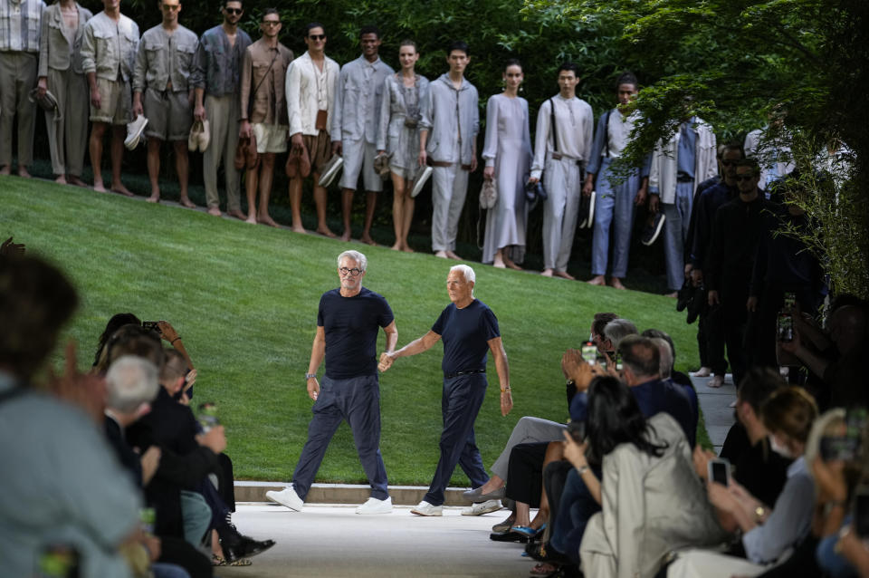 Giorgio Armani, centre right, and Leo Dell'Orco, centre left, accept applause at the conclusion of the Giorgio Armani men's Spring Summer 2022 collection, in Milan, Italy, Monday, June 21, 2021. (AP Photo/Luca Bruno)