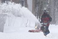 A man clears his driveway with a snow blower during a snowstorm in Quebec City, December 15, 2013. Between 15 and 30cm of snow are expected to fall on the different regions of eastern Canada today, according to Environment Canada. REUTERS/Mathieu Belanger (CANADA - Tags: ENVIRONMENT SOCIETY)