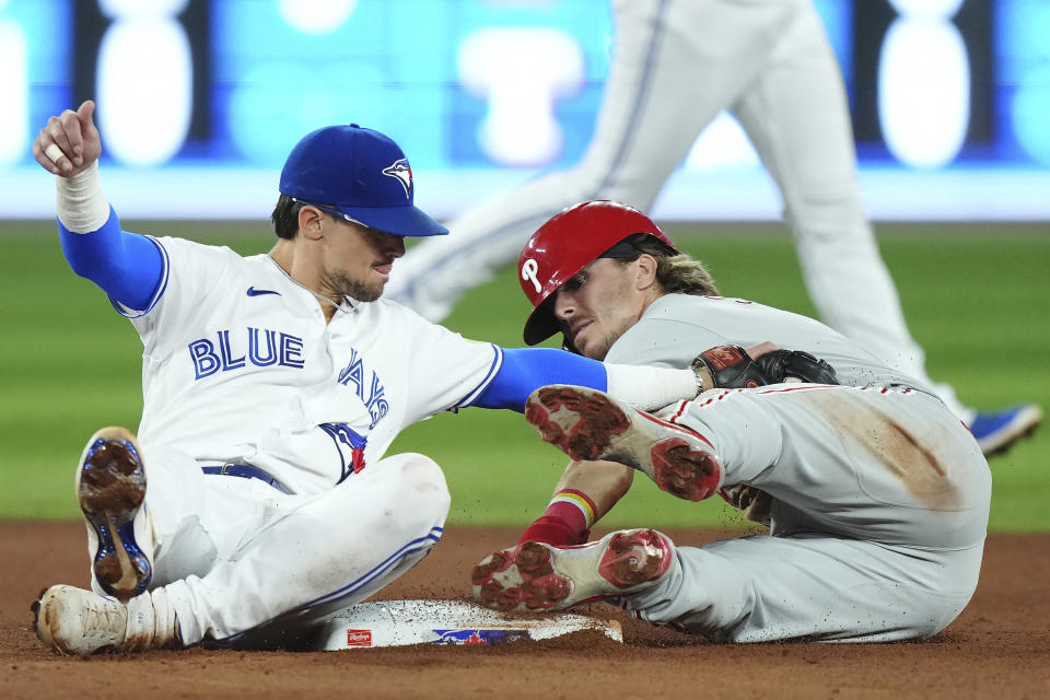 Philadelphia Phillies' Bryson Stott, right, steals second base ahead of the tag from Toronto Blue Jays second baseman Cavan Biggio (8) during the seventh inning of a baseball game in Toronto on Tuesday, Aug. 15, 2023. (Nathan Denette/The Canadian Press via AP)