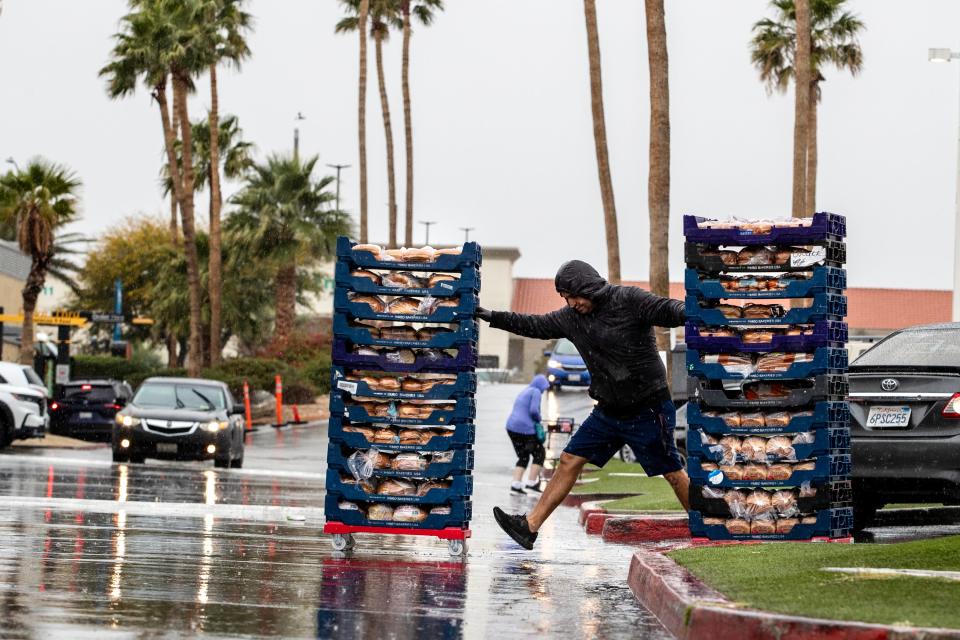 People navigate flooding parking lots in Desert Hot Springs on Thursday.