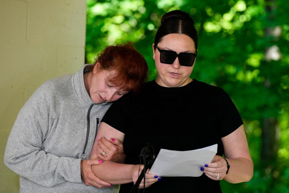 Melody Kernan holds on to her daughter, Katie Duncan as she reads a statement about her stepfather, Nicholas Kernan, 43, who was found shot while working in Corryville.