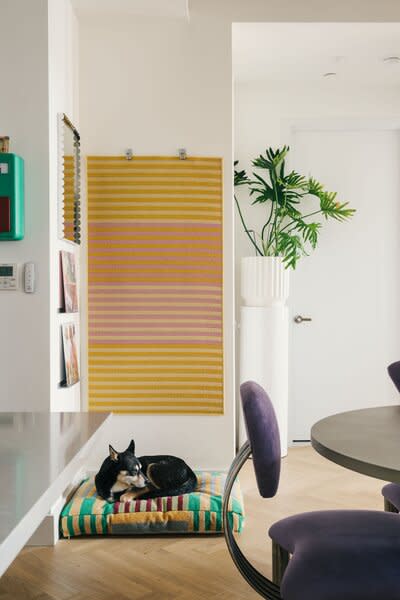 This alcove beside the entryway is where Shabu Shabu sleeps. The dog bed is from Dusen Dusen, the mirror is from HAY, and the wall hanging is an IKEA rug that the couple uses to cover an electrical outlet.