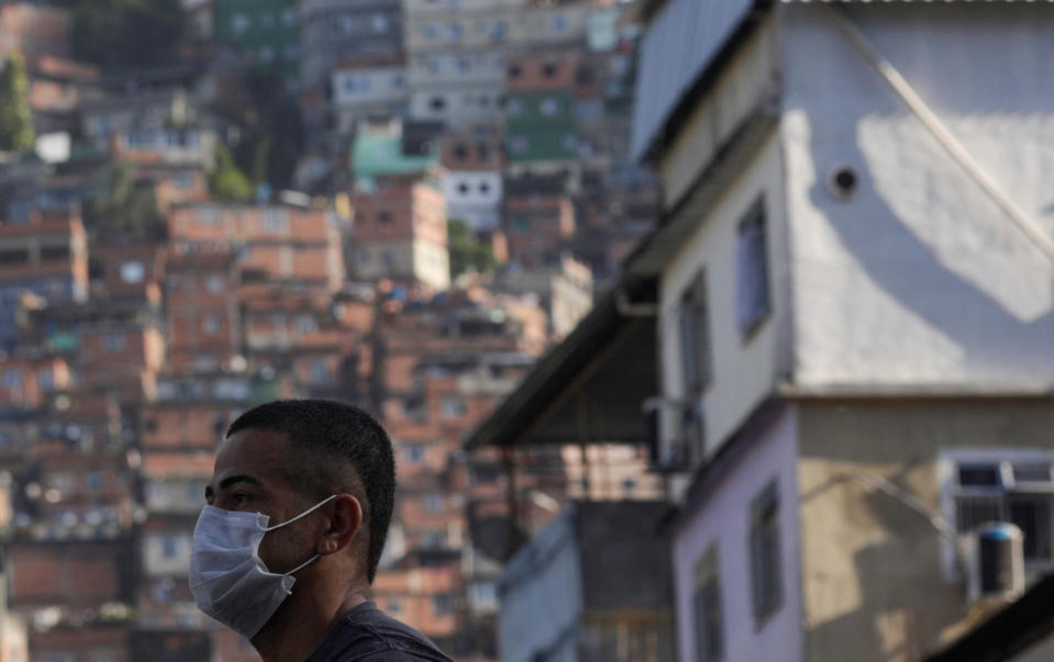 A man wearing a protective mask outside Rocinha Slum waits for a public bus during the coronavirus disease (COVID-19) outbreak in Rio de Janeiro