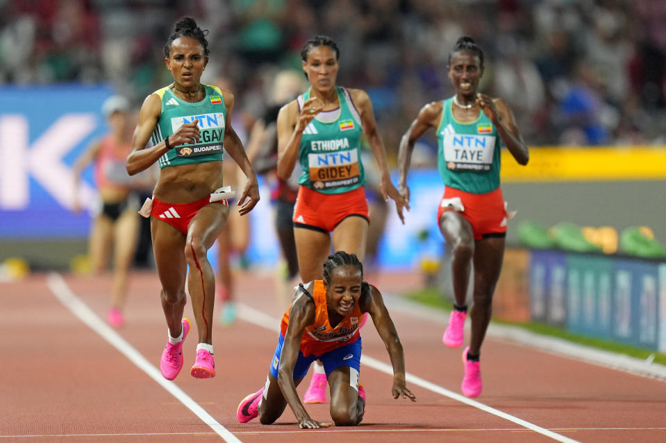 Sifan Hassan, of the Netherlands falls as she approaches the finish leaving Gudaf Tsegay, of Ethiopia, left, to win the gold medal in the final of the Women's 10000-meters during the World Athletics Championships in Budapest, Hungary, Saturday, Aug. 19, 2023. (AP Photo/Petr David Josek)