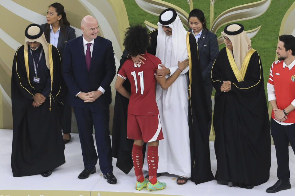 Qatar's Amir Sheikh Tamim bin Hamad Al Thani, centre, greet Qatar's Akram Afif at the end of the Asian Cup final soccer match between Qatar and Jordan at the Lusail Stadium in Lusail, Qatar, Saturday, Feb. 10, 2024. (AP Photo/Hussein Sayed)