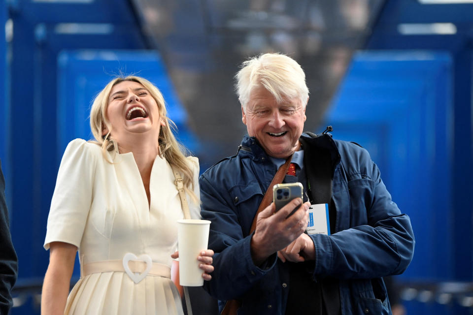 Stanley Johnson, father of former British Prime Minister, Boris Johnson, reacts as he walks between venues with British reality TV personality Georgia Toffolo during Britain's Conservative Party's annual conference in Birmingham, Britain, October 3, 2022. REUTERS/Toby Melville