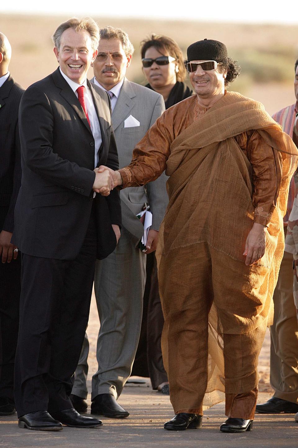 This is one of the fashionista's few fashion blunders in the noughties. With the passing of time, his figure isn't what it was, and these draped trousers are unforgiving on the thighs. The golden sunglasses do not do enough to distract from the problems around the waistline.     Gaddafi meets Blair in 2007 in Sirte, Libya. 