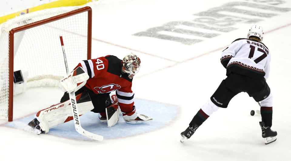 Arizona Coyotes center Nick Bjugstad (17) scores against New Jersey Devils goaltender Akira Schmid (40) during a shootout of an NHL hockey game Friday, Oct. 13, 2023, in Newark, N.J. (AP Photo/Noah K. Murray)