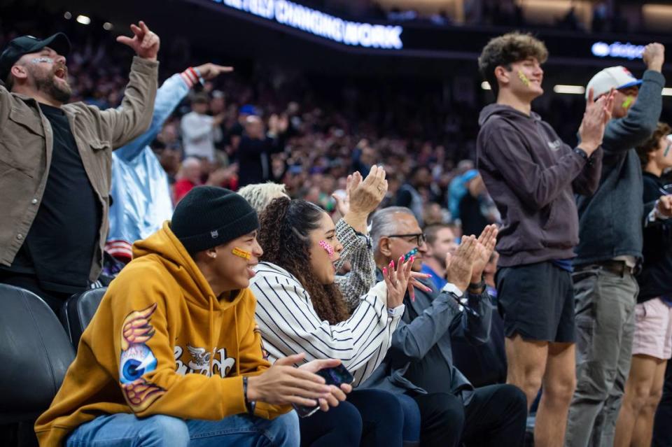 Recee Caldwell, center, De’Aaron Fox’s wife, cheers against the Golden State Warriors on Sunday. Caldwell is among the spectators wearing Band-Aids in reference to Malik Monk’s recent facial injury