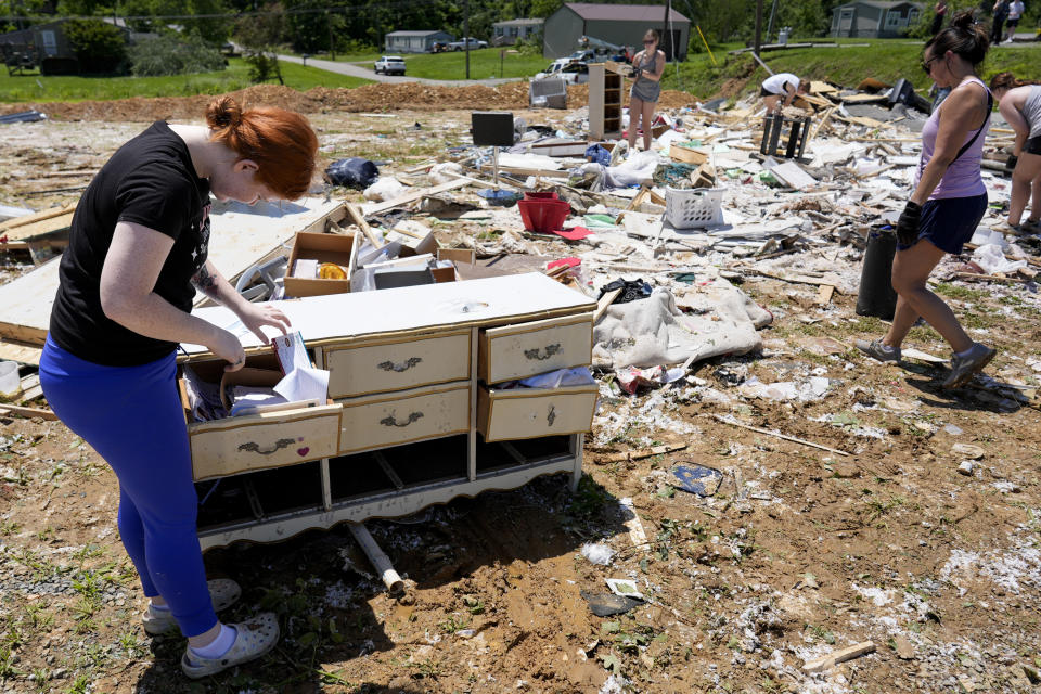 Haley Loukota, searches for her belongings among storm debris along Barnsley Loop, Tuesday, May 28, 2024, in Madisonville, Ky. Her home was demolished after a series of powerful storms hit the central and southern U.S. over the Memorial Day holiday weekend. (AP Photo/George Walker IV)