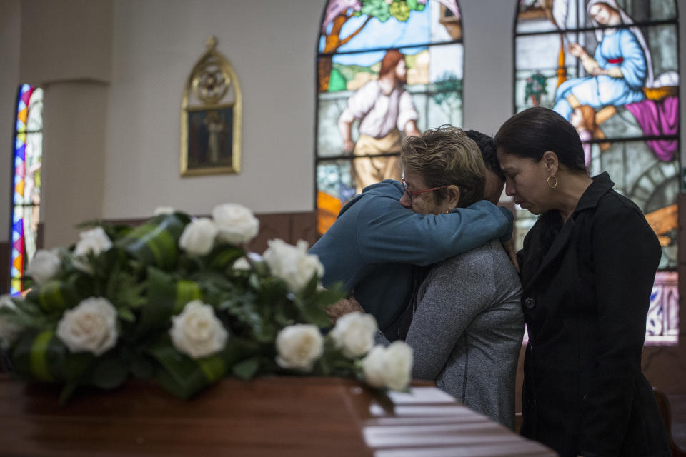 Familiares lloran la muerte de la excombatiente rebelde Astrid Conde durante su funeral en Bogotá el 8 de marzo del 2020. Conde se había acogido a un acuerdo de paz y había entregado las armas, pero murió asesinada a tiros el 5 de marzo. (AP Photo/Iván Valencia)