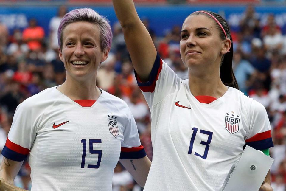 <p>Alessandra Tarantino/AP</p> USWNT Megan Rapinoe and Alex Morgan teammates celebrating their win at the 2019 World Cup