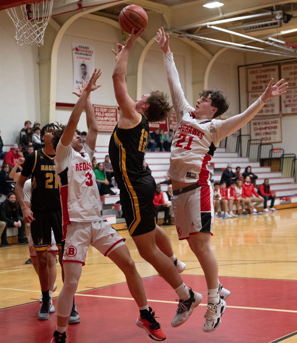 Nauset's Dillon White, #12, along with Barnstable's Ewerton Decastro, #3, and Tristan Vermette, #21, go for the rebound in the Barnstable Redhawks vs Nauset Warriors game hosted by Barnstable High School on Tuesday night.