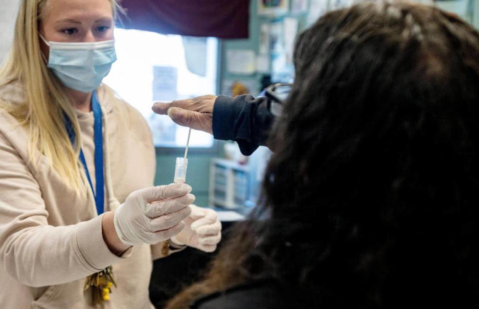 Interfaith Sanctuary Shelter Director Jordan Pereira collects a COVID test from a resident on Wednesday. The homeless crisis center has moved to daily mass testing after a surge of positive COVID cases among residents.