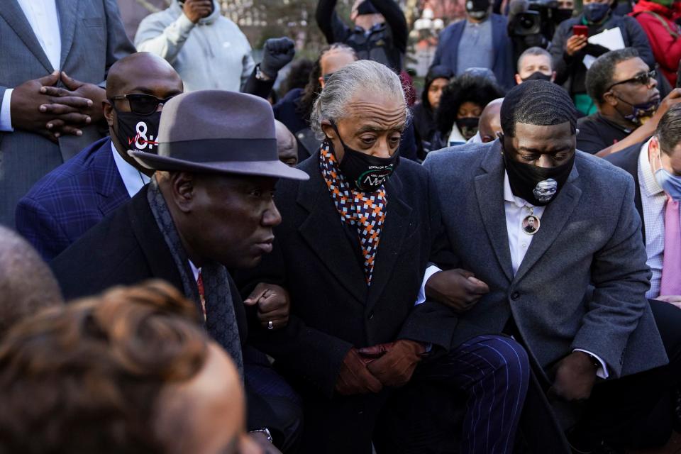 On the morning of March 29, the first day of the trial for the officer that killed George Floyd, civil rights attorney Ben Crump, left, Al Sharpton, center, and family members of George Floyd take a knee in remembrance.