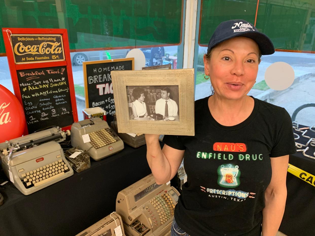 Manager and owner Laura Lebay holds up a picture of her parents taken at Nau's Enfield Drug. Her mother was pregnant with Laura when her parents purchased the 1951 drugstore from the Nau family in 1971. Almost all the store's contents go on sale this weekend.