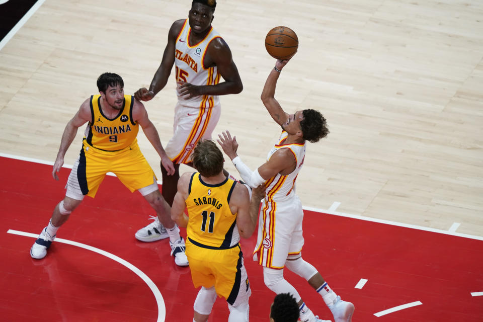 Atlanta Hawks Trae Young, right, shoots the ball against Indiana Pacers' Domantas Sabonis, left, during the first half of an NBA basketball game on Sunday, April 18, 2021, in Atlanta. (AP Photo/Brynn Anderson)