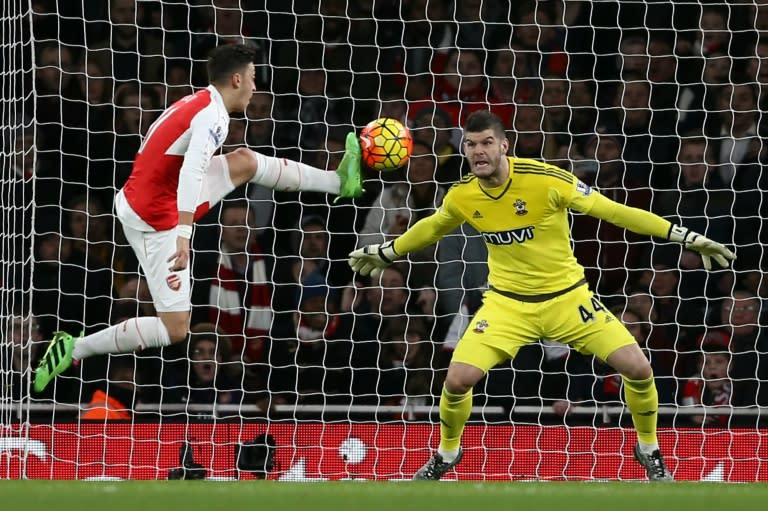 Arsenal's Mesut Ozil (L) fails to score past Southampton 'keeper Fraser Forster during their English Premier League match at the Emirates Stadium