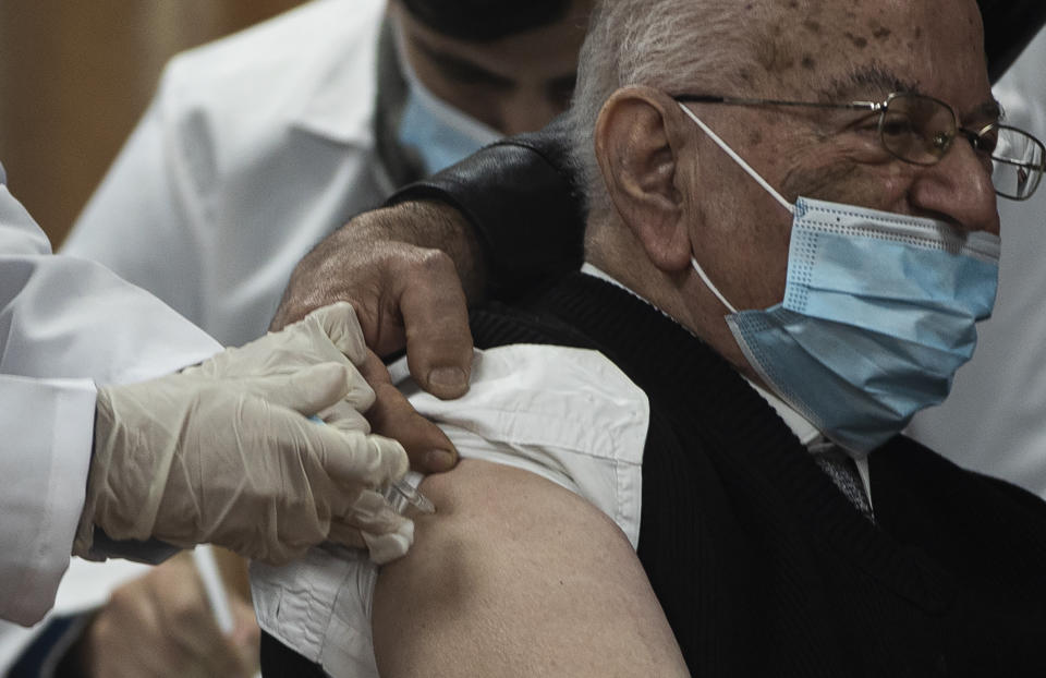Former Palestinian Health Minister Riyad al-Zanoun receives a shot of the Russian-made Sputnik V coronavirus vaccine, in Gaza City, Monday, Feb. 22, 2021. (AP Photo/Khalil Hamra)