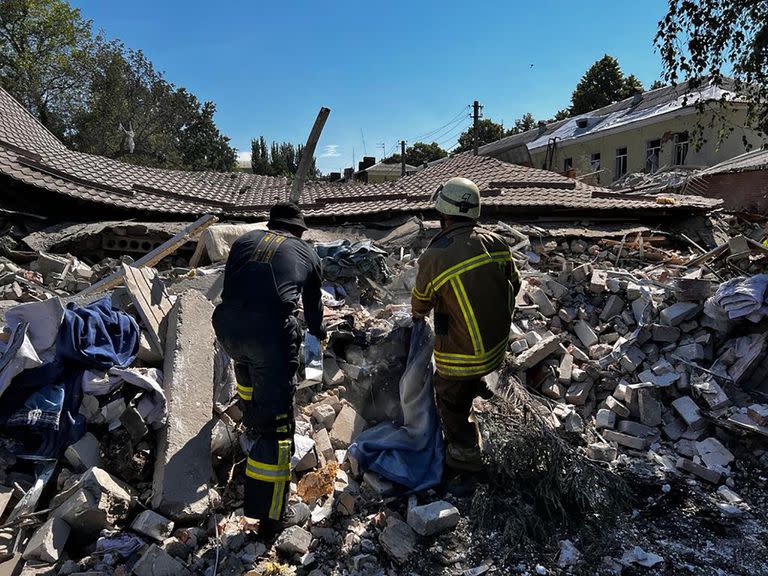 Esta fotografía publicada por el Servicio de Emergencia de Ucrania el 27 de julio de 2022 muestra a los rescatistas limpiando los escombros de un edificio parcialmente destruido como resultado del ataque con misiles a Bakhmut, región de Donetsk, en medio de la invasión rusa de Ucrania. 