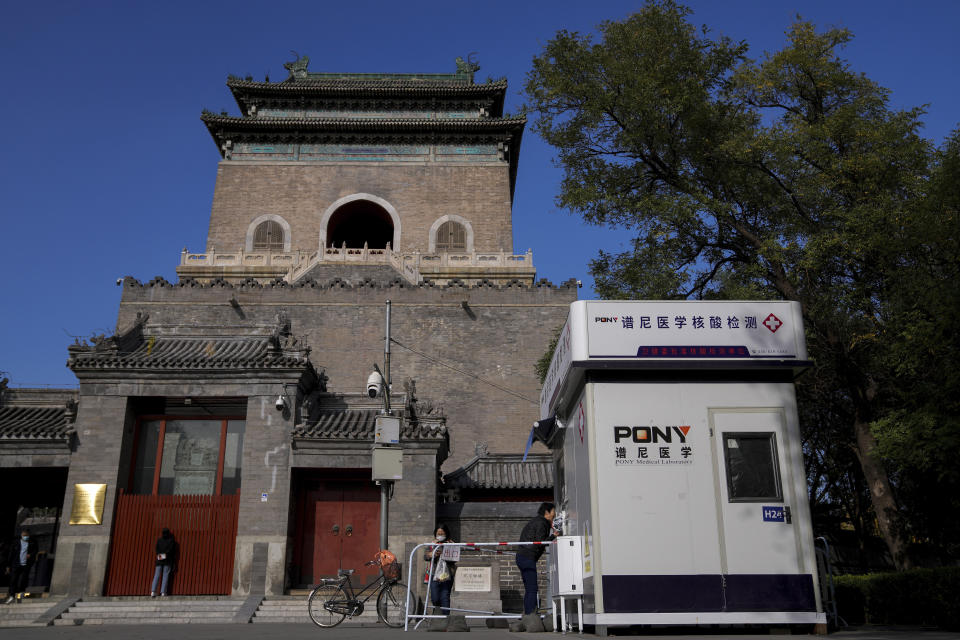 Residents get their routine COVID-19 throat swabs at a coronavirus testing site setup outside the Drum Tower in Beijing, Tuesday, Nov. 1, 2022. Visitors to Shanghai Disneyland were temporarily blocked from leaving as part of virus testing that extended to more than 400,000 people, the city government announced Tuesday. (AP Photo/Andy Wong)