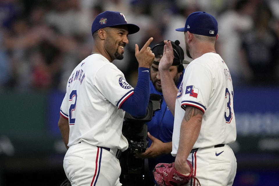 Texas Rangers' Marcus Semien, left, and Kirby Yates, right, celebrate after their win over the Tampa Bay Rays in a baseball game in Arlington, Texas, Saturday, July 6, 2024. (AP Photo/Tony Gutierrez)