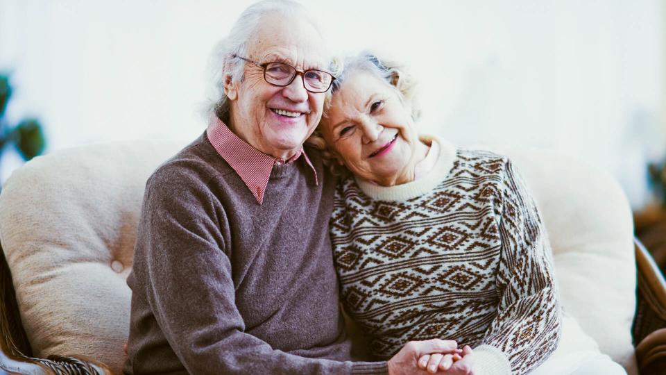 happy elderly couple sitting on a couch