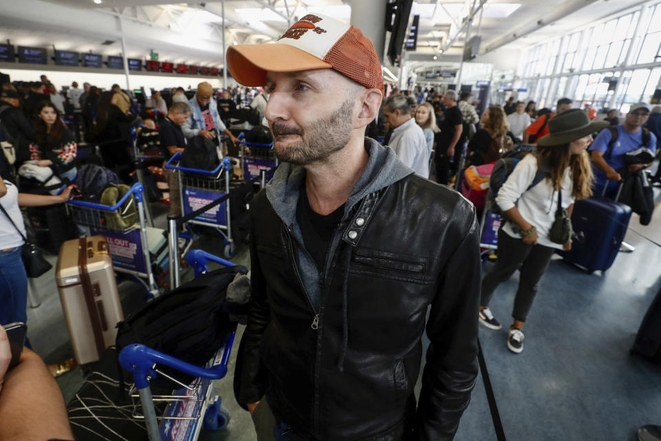 Passenger Larry Reef prepares to check in at Auckland, New Zealand airport for a LATAM Airlines flight to Santiago, Chile, Tuesday, March 12, 2024. LATAM said a flight Monday from Sydney to Auckland experienced “strong movement” that injured at least 50 people. Reef was on the flight Monday.(Dean Purcell/New Zealand Herald via AP)