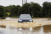 A car drives through a flooded road in Yapton, England, Thursday, Nov. 2, 2023. Winds up to 180 kilometers per hour (108 mph) slammed France's Atlantic coast overnight as Storm Ciaran lashed countries around western Europe, uprooting trees, blowing out windows and leaving 1.2 million French households without electricity Thursday. Strong winds and rain also battered southern England and the Channel Islands, where gusts of more than 160 kph (100 mph) were reported. (Joe Sene/PA via AP)