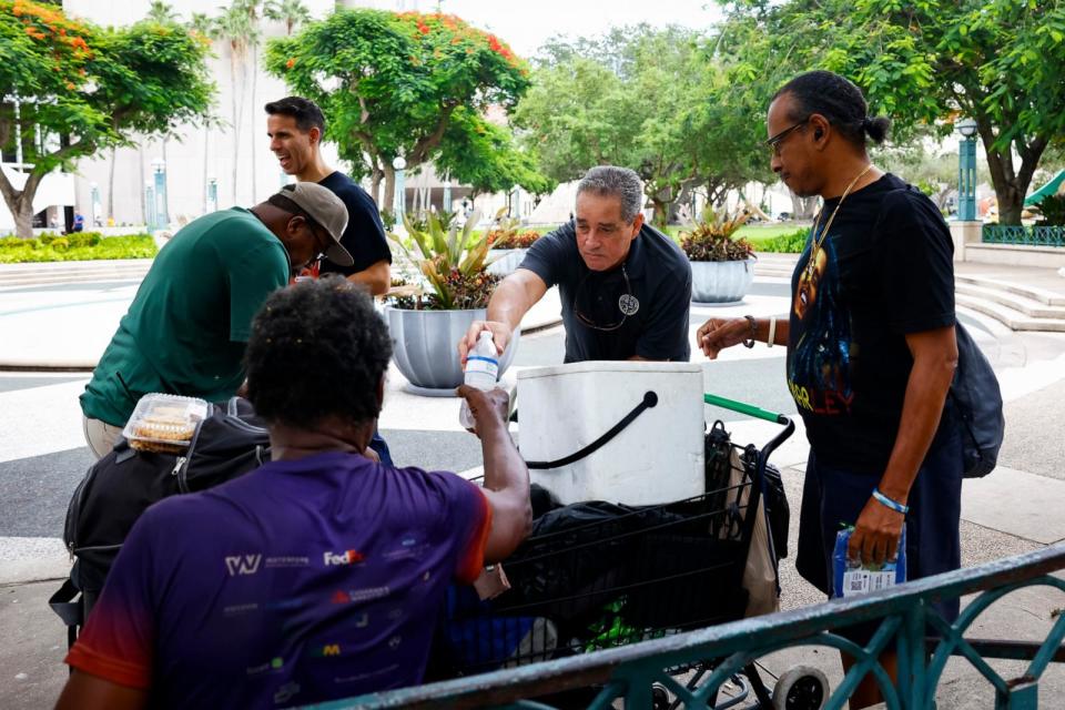 PHOTO: Miami-Dade County Homeless Trust representatives distribute bottles of water and shelter information during a heat wave in Miami, on July 25, 2023. (Eva Marie Uzcategui/Bloomberg via Getty Images, FILE)