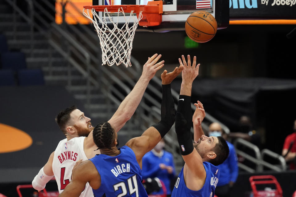Toronto Raptors center Aron Baynes (46) goes up for a rebound with Orlando Magic center Nikola Vucevic (9) and center Khem Birch (24) during the first half of an NBA basketball game Sunday, Jan. 31, 2021, in Tampa, Fla. (AP Photo/Chris O'Meara)