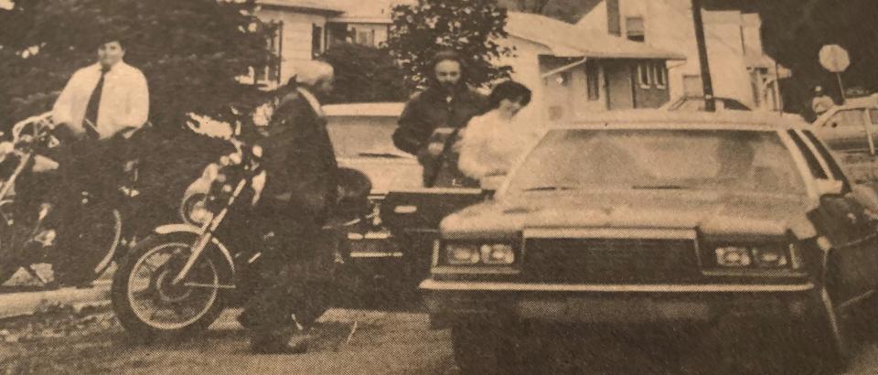 Reporter Larry Reisman, stands at left, while Pennsylvania State Police Lt. Joseph Skapik watches Larry Oswald and his daughter, Pamela Hillegass, get into a police car after a standoff Nov. 1, 1982, in Walnutport, Pennsylvania.