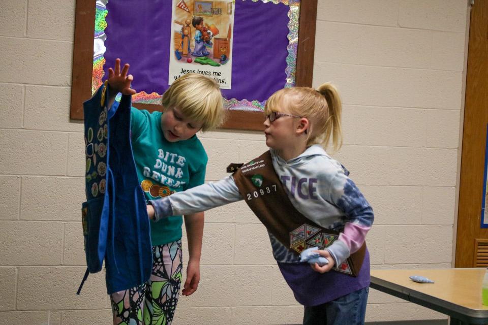Malea Jones, 7, (left) and Courtney Dority, 7, (right) share their badges with one another at the Jan. 14 workshop.