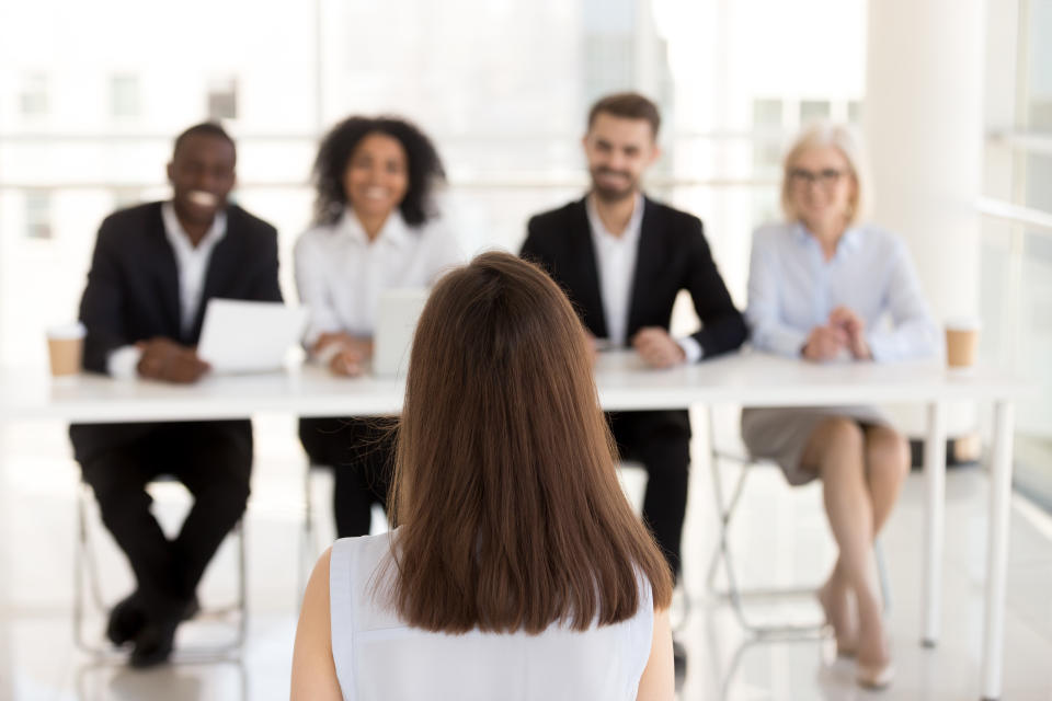 Back view of female job applicant make good first impression at work interview in office, millennial woman candidate talk, impress HR managers or recruiters at hiring. Employment concept