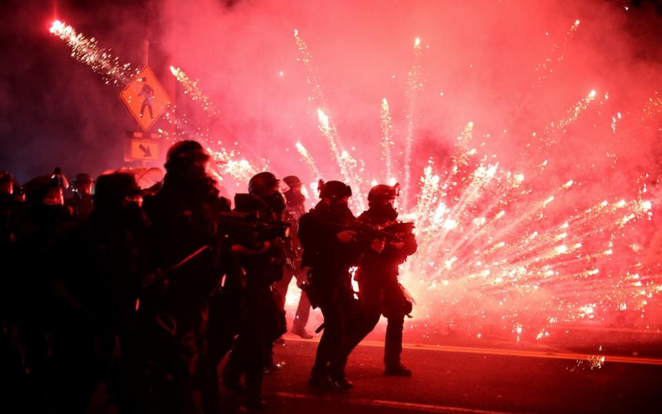 Police advance on protesters to clear a street on the 100th consecutive night of protests against police violence and racial inequality, in Portland, Oregon - Reuters