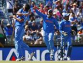 India's Mohammed Shami (L) and Suresh Raina (C) celebrate after West Indies batsman Dwayne Smith was caught by wicket keeper MS Dhoni (R) during their Cricket World Cup match in Perth, March 6, 2015. REUTERS/David Gray