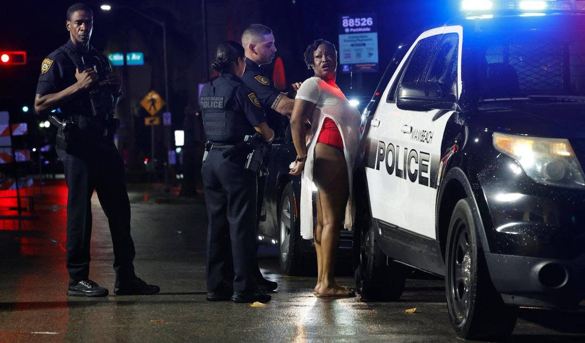 A woman is detained by Miami Beach police during spring break on Miami Beach, Florida on Saturday, March 17, 2024.
