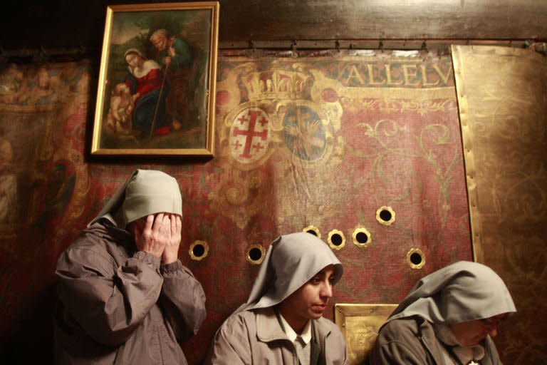 Sisters from the Franciscan order pray inside the Grotto at the Church of the Nativity in the biblical West Bank city of Bethlehem on December 24, 2012. Thousands of people streamed into the West Bank city of Bethlehem to mark Christmas, as the Latin Patriarch urged "men of good will" to seek peace in the Middle East