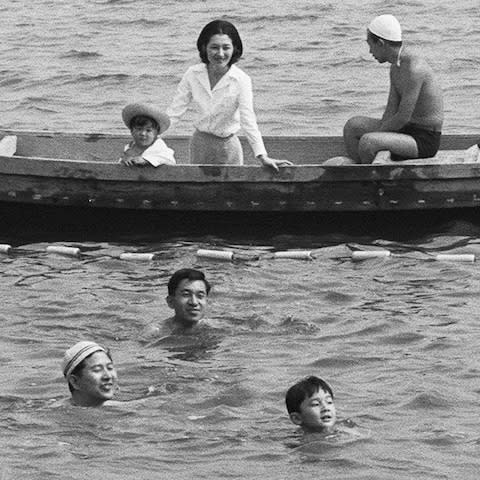 Emperor Akihito (swimming C), Empress Michiko (on boat C) and Prince Akishino (on boat L) watching Crown Prince Naruhito (swimming R) swimming in 1968 - Credit: KARYN NISHIMURAJIJI PRESS/AFP/Getty Images